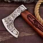 Hand-forged carbon steel camping axe with rose wood handle and leather sheath.