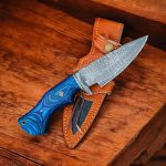 A 10-inch handmade hunting knife crafted from Damascus steel, featuring a blue wood handle and accompanied by a leather sheath.